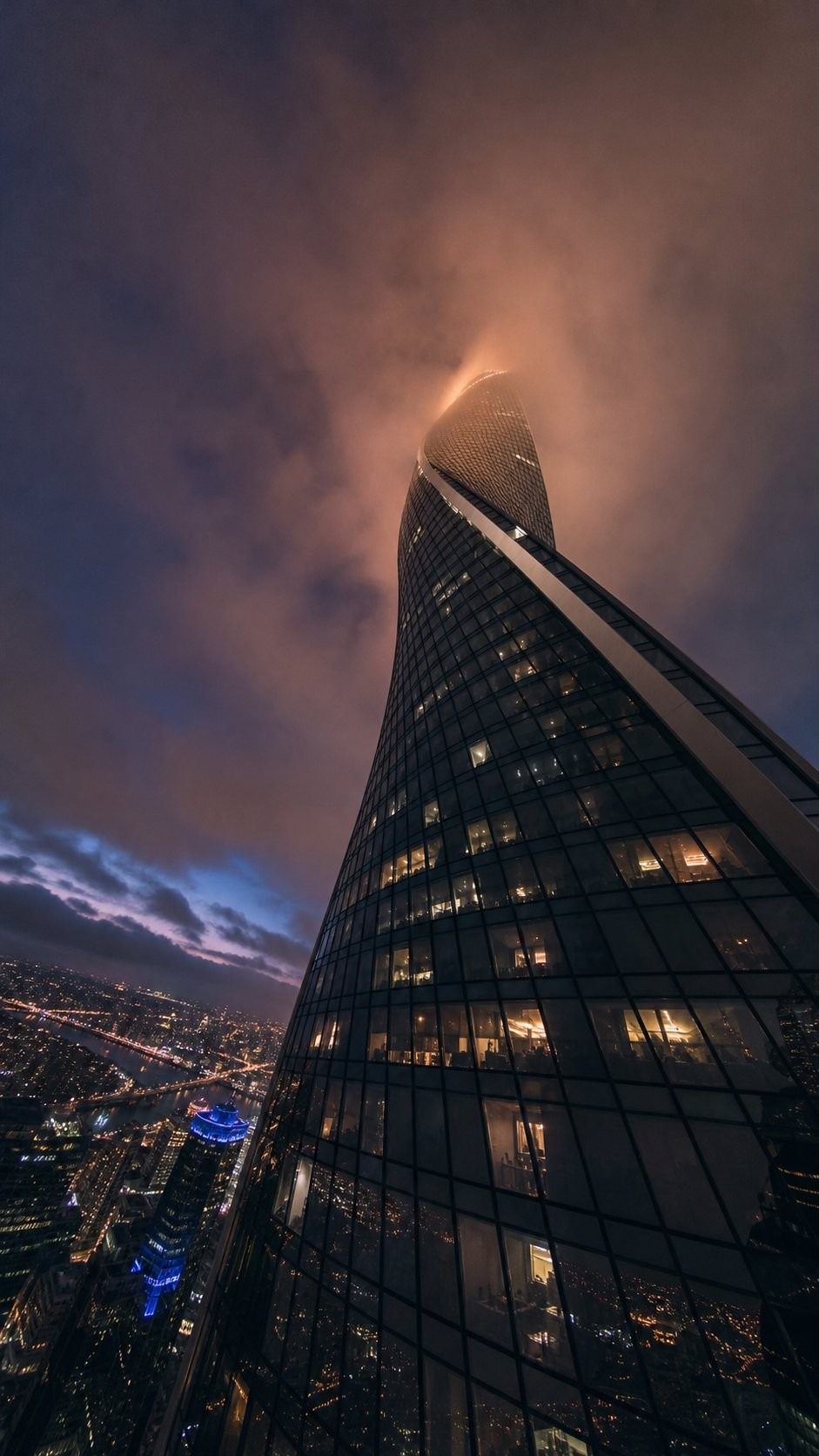 Torre Axis climbing into a low dusk sky above the city